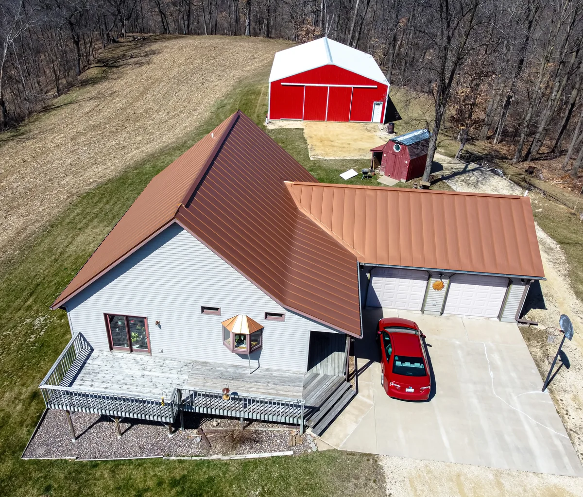 Brown standing-seam metal roof seen above a house, with a curved roof transition.